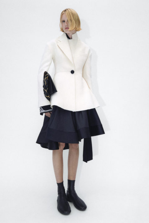 The model wears a white jacket, black skirt and black bag by Proenza Schouler, which was released in the spring of 2023.