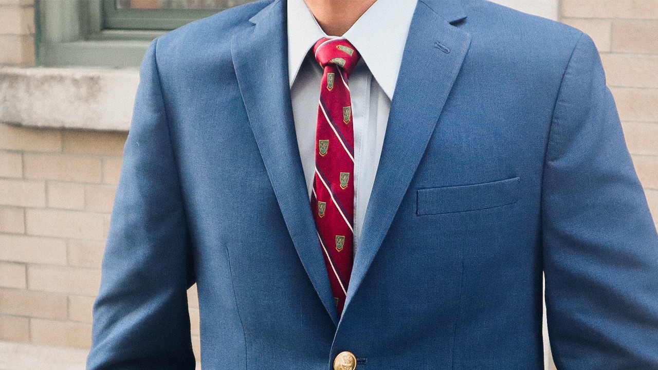 closeup of man in blue suit jacket and red tie