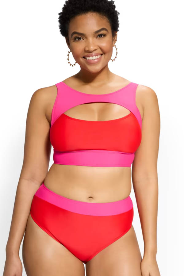A smiling model wears a New York & Company colorblock swimsuit.